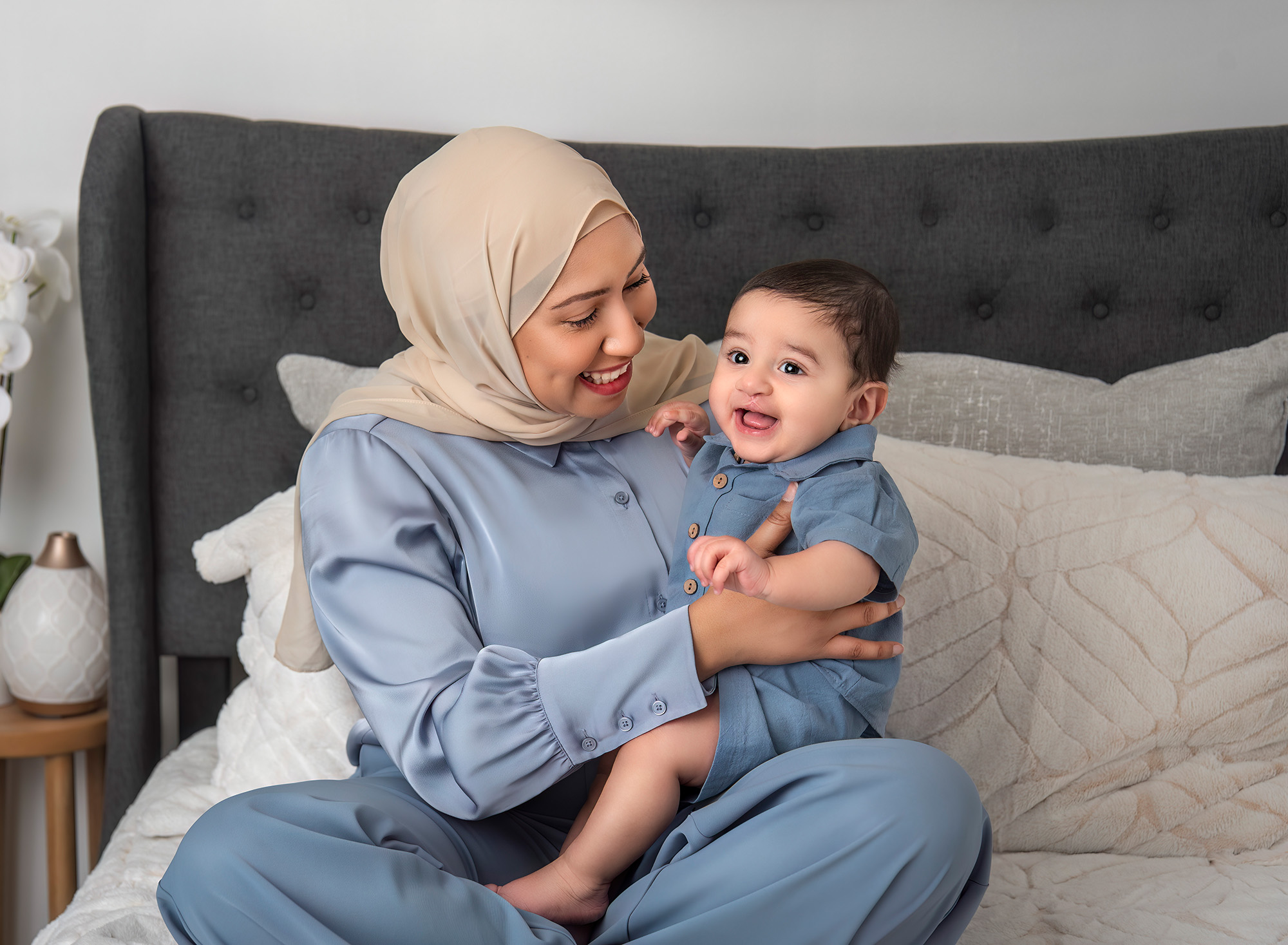 Candid In Studio Family Photos Mother smiling at baby sitting on her lap