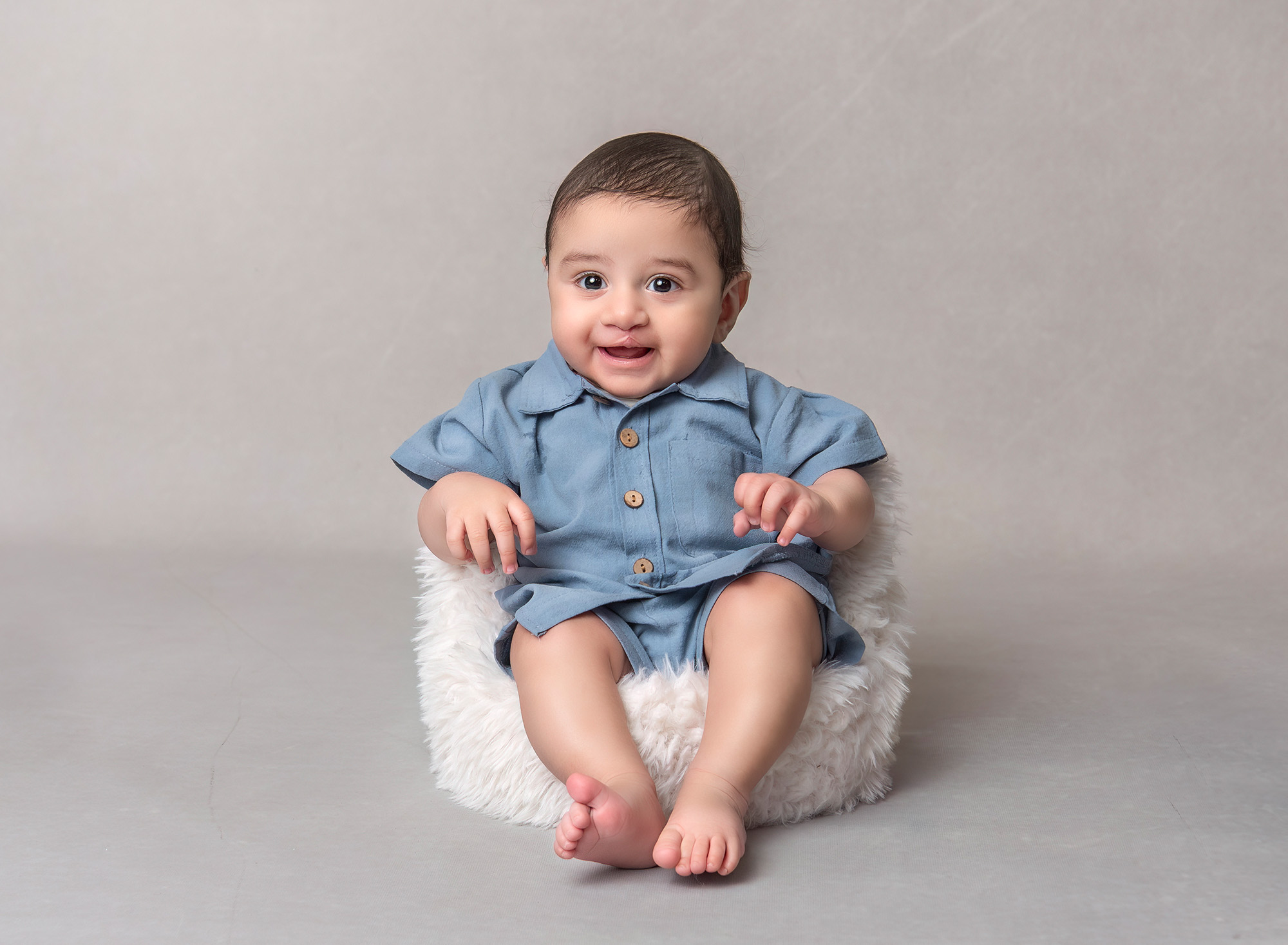 Three month old smiling in a fuzzy chair