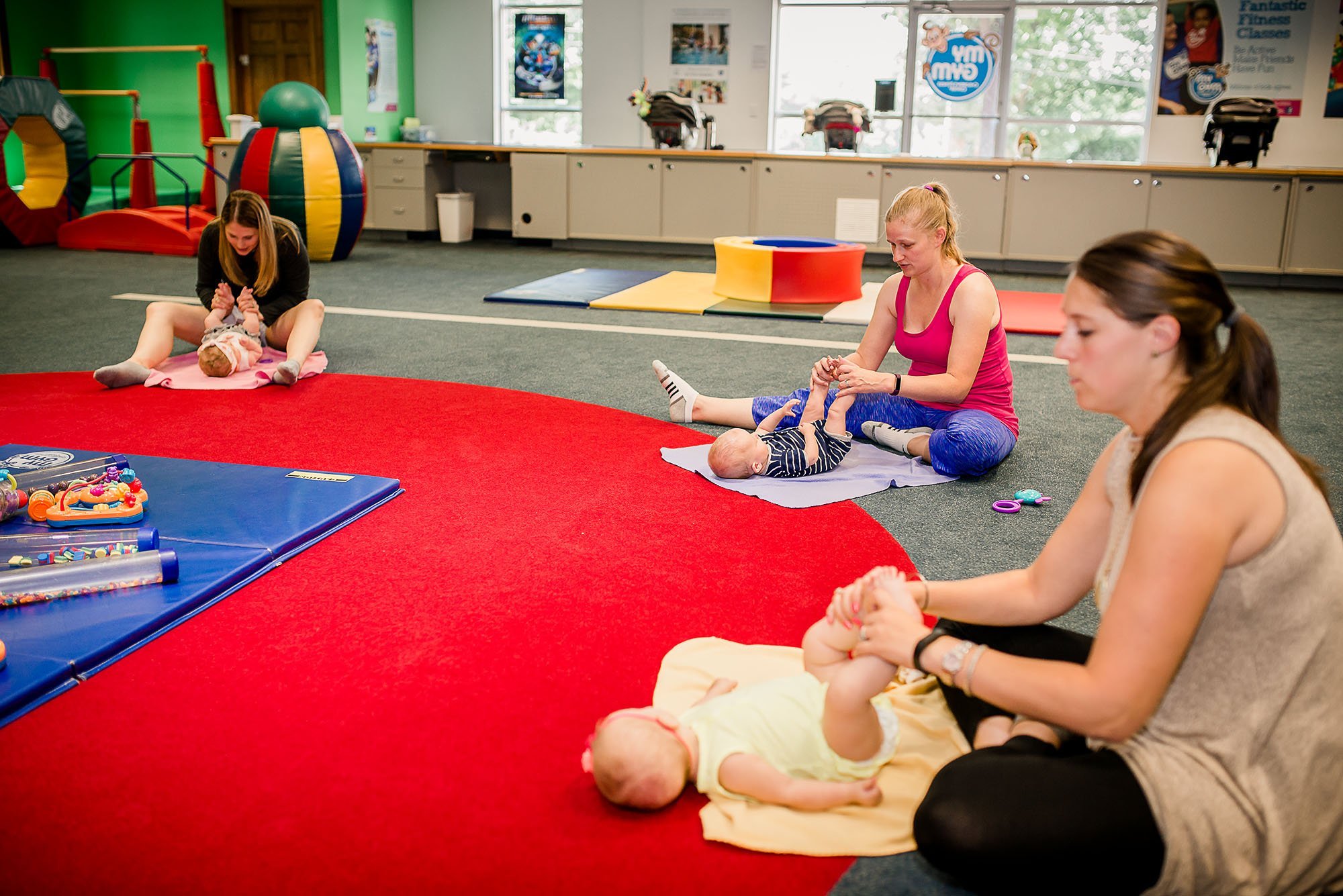 Moms touching their baby's toes to music at My Gym Glastonbury