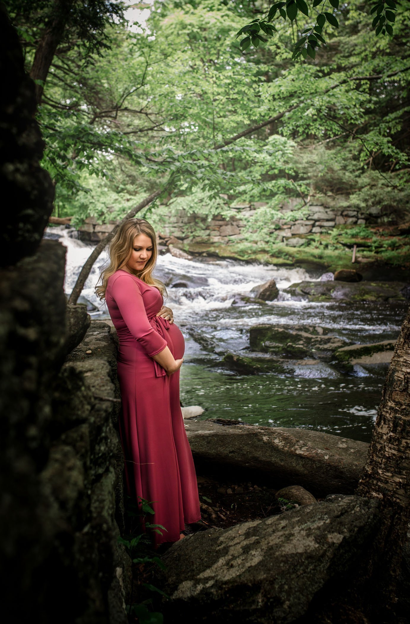 Maternity standing in forest with river behind
