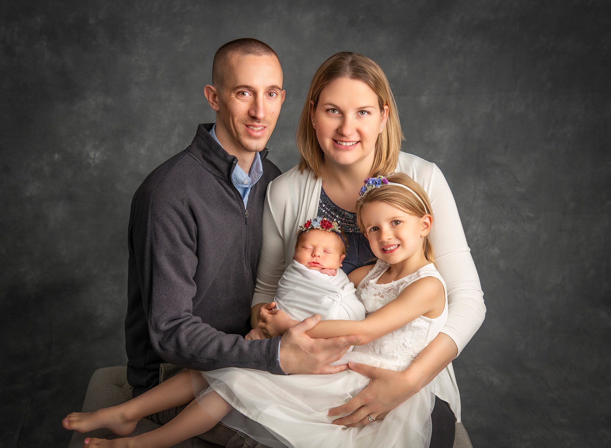 big sister and newborn family photo with mom, dad and both girls