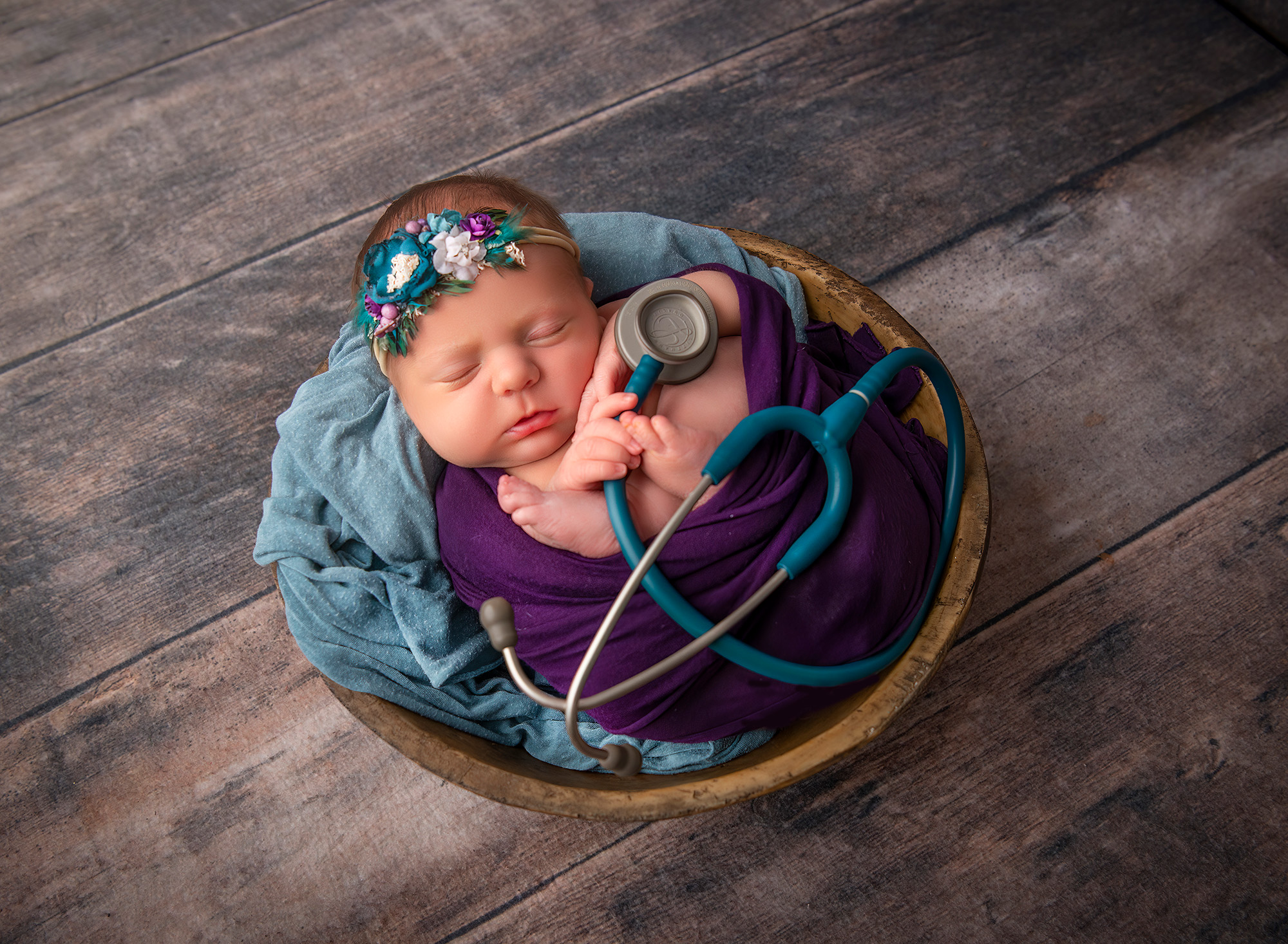 maternity & newborn photoshoot newborn baby sleeping in a bowl with mom's stethoscope