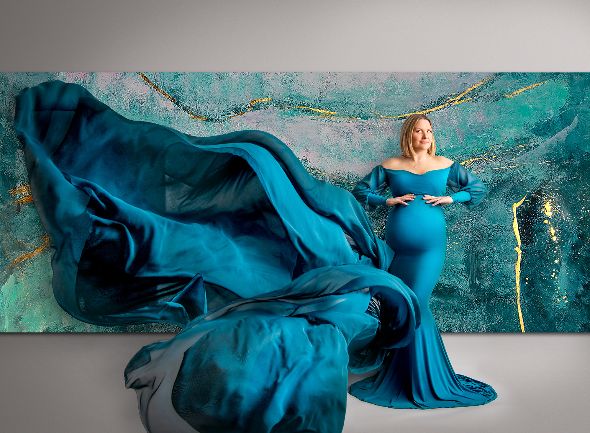 maternity and newborn photoshoot Mom exuded elegance in a stunning deep teal gown from our maternity collection, its flowing train adding a touch of whimsy to the photographs