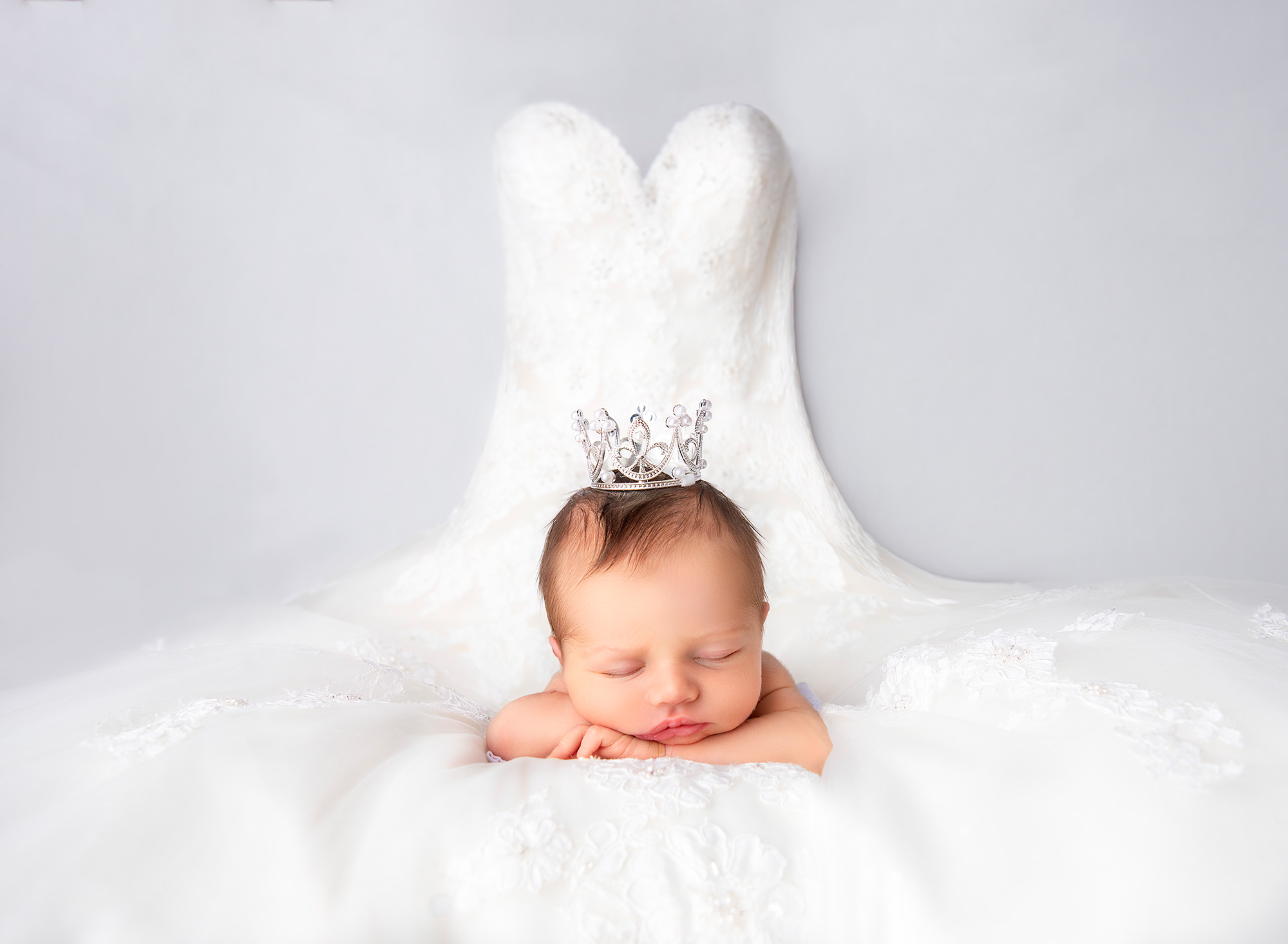 maternity and newborn photography Baby Brooklyn sleeping on Mom's wedding dress, with the bodice hung behind her. 