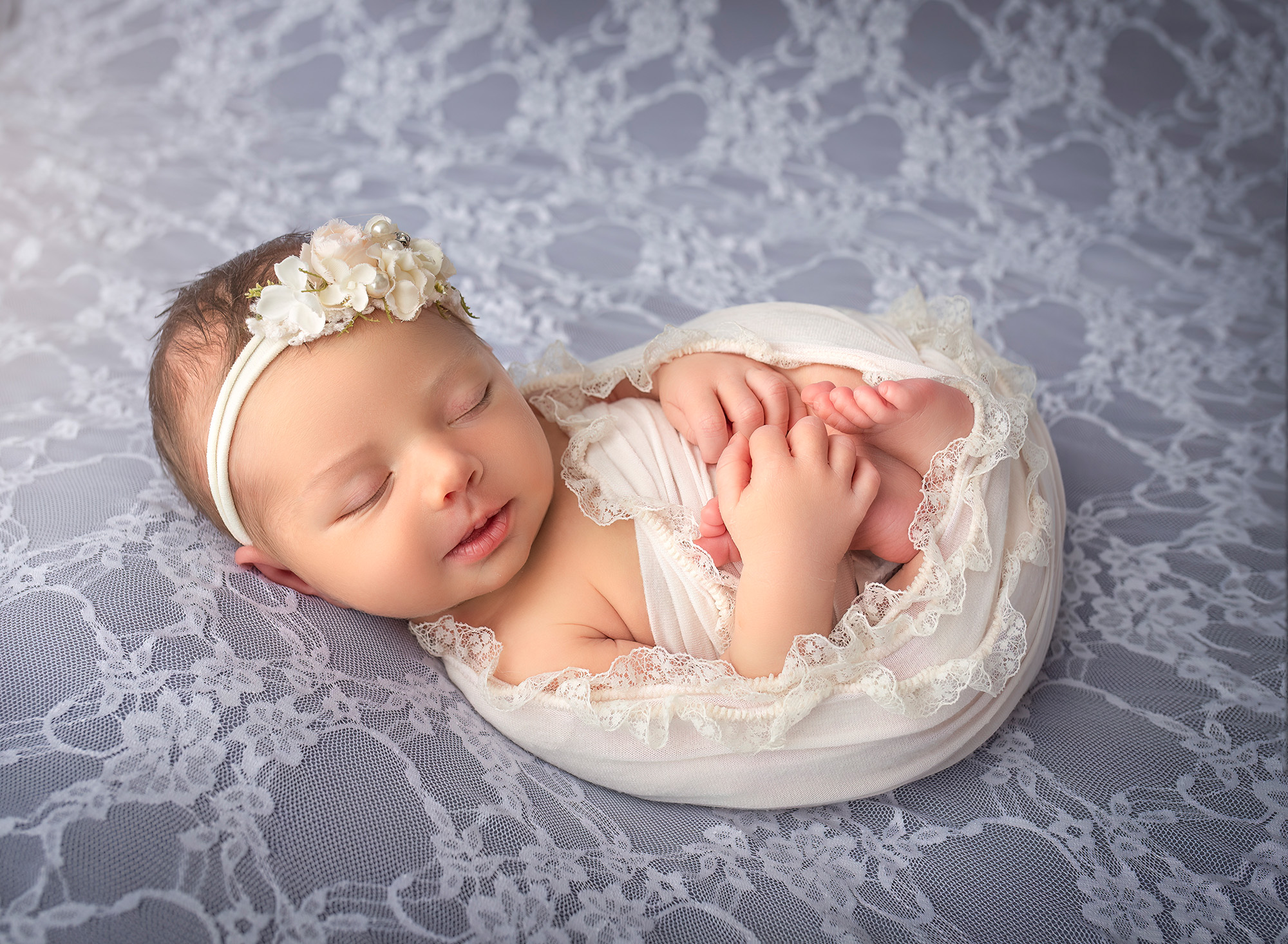 maternity and newborn photography Brooklyn sleeping on a lavender-colored bed covered in lace, swaddled and sleeping on her back. 