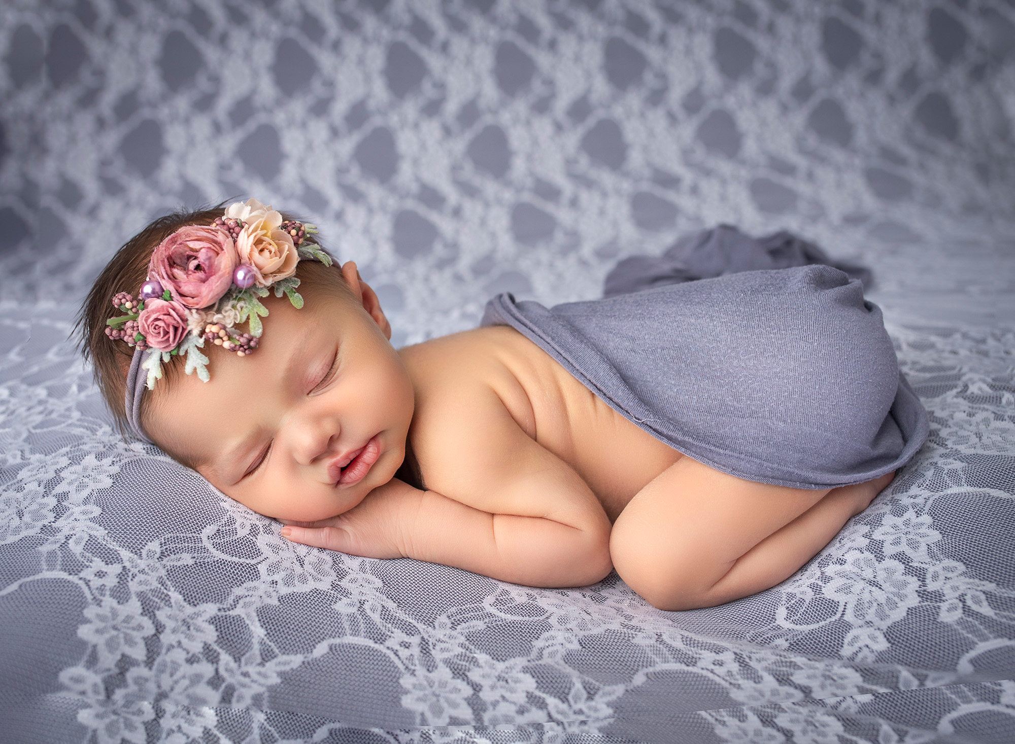 Brooklyn sleeping on her tummy on the lavender-colored bed, with her bottom covered. 