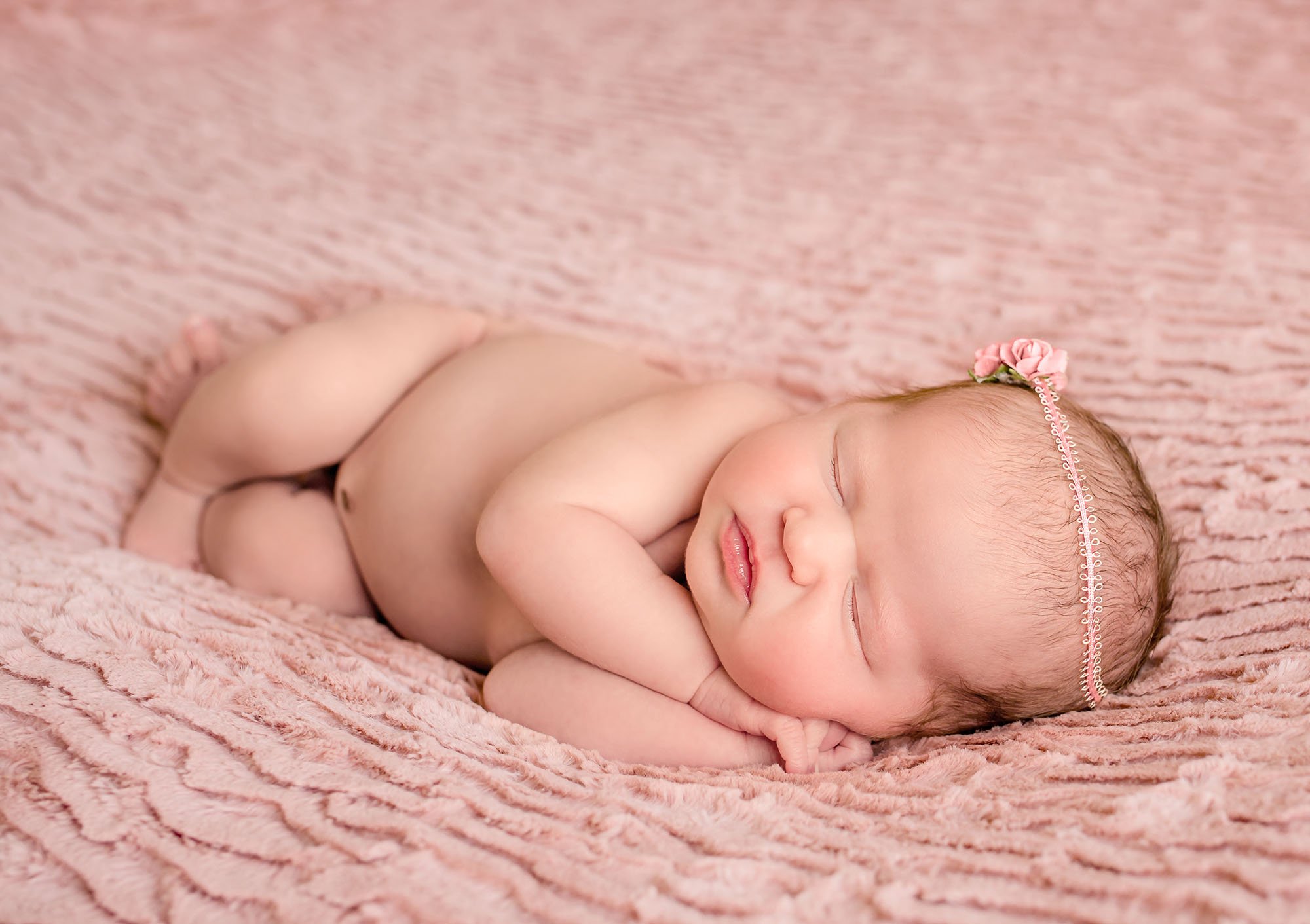newborn baby girl sleeping on pink with rose headband One Big Happy Photo
