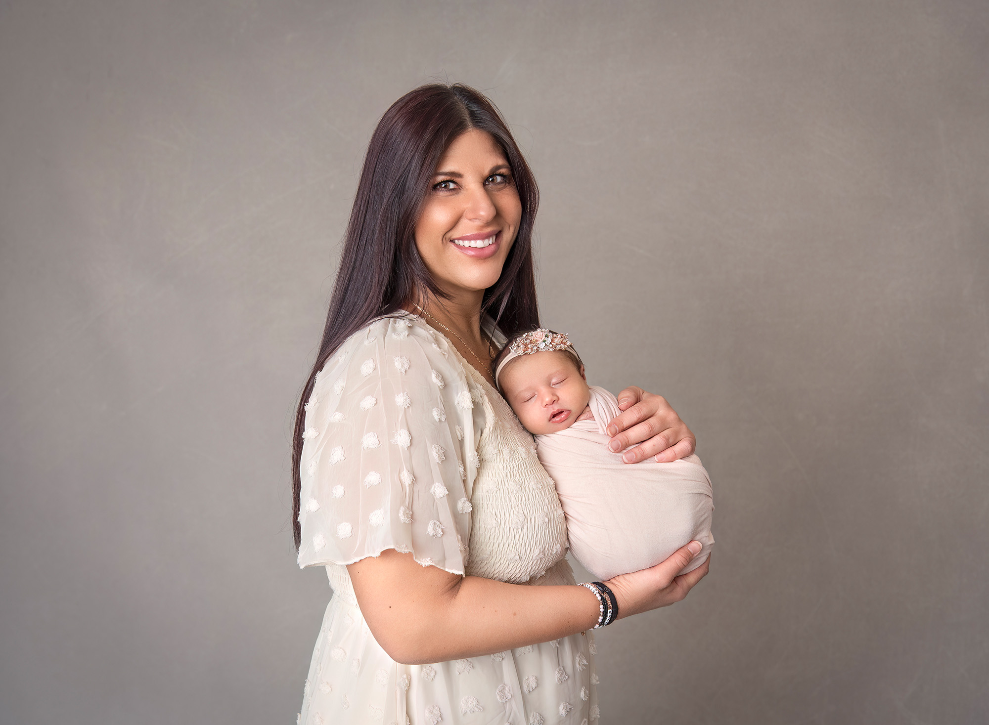 Newborn Maternity Photographer mom holding her first baby girl wrapped on her chest