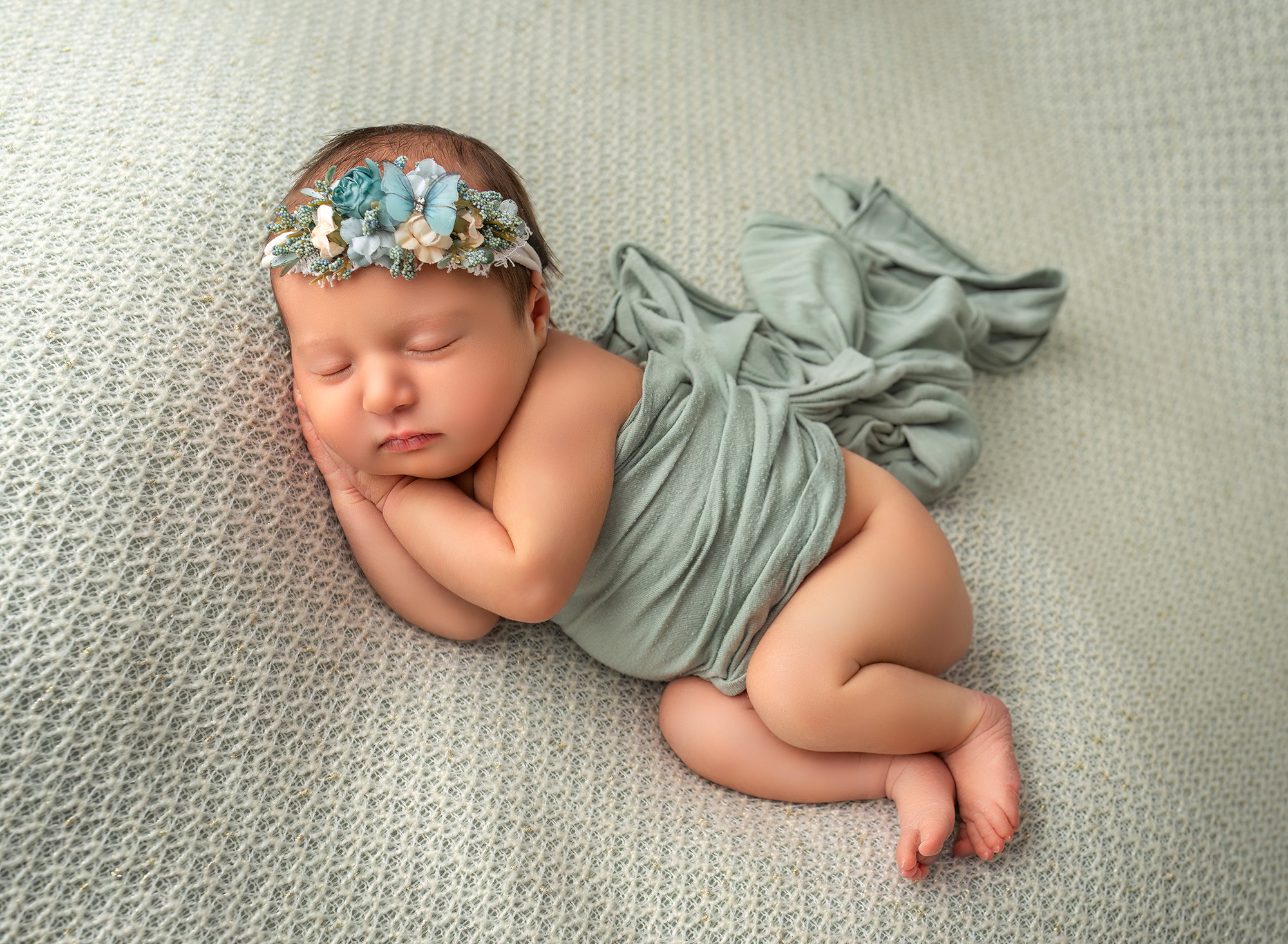 bab girl sleeping on her side with her hands under her cheek with a headband that has a butterfly on it Newborn Maternity Photographer