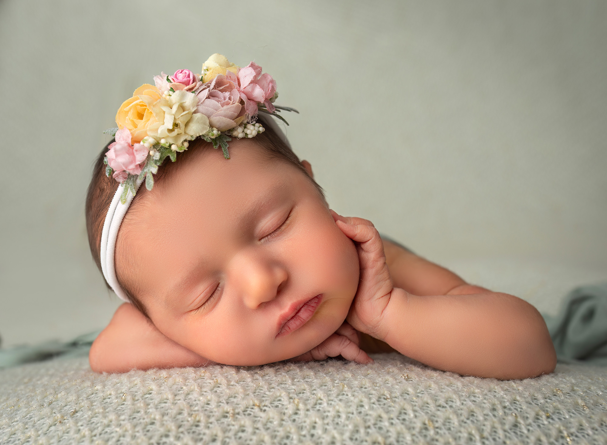 newborn baby girl sleeping with her hand resting on her cheek. Newborn Maternity Photographer