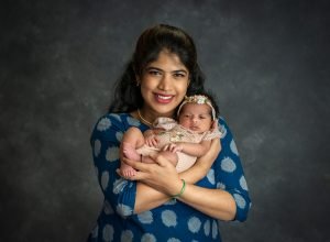 new mom cradling newborn baby girl close to her chest